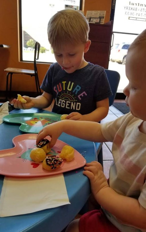 Two children enjoying donuts